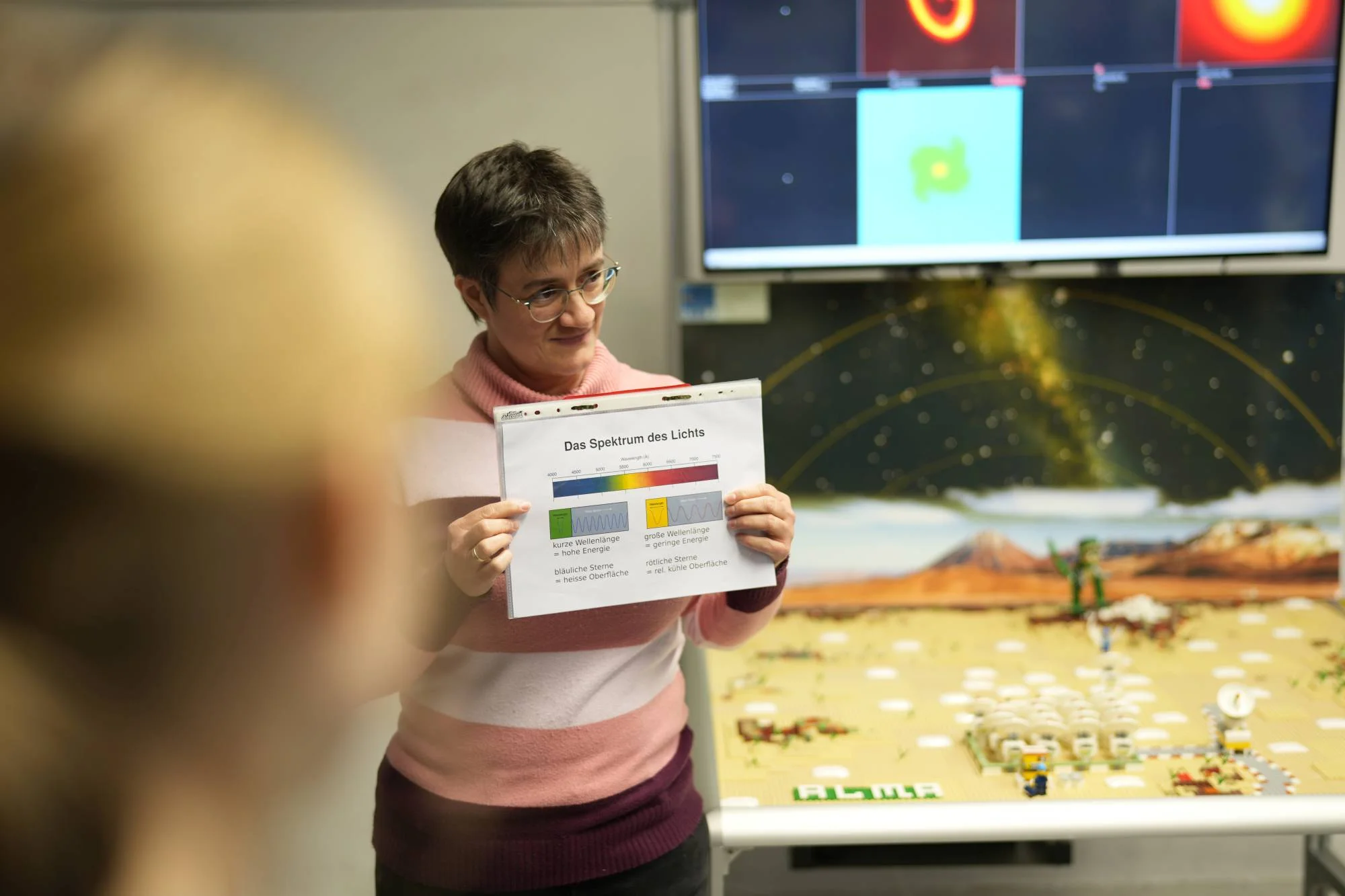 Stefanie explains the spectrum of light in front of the LEGO model of the ALMA radio telescope